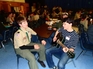 Savage plays music while chatting with Dylan Bunker from Troop 201 at the Merit Badge College. 